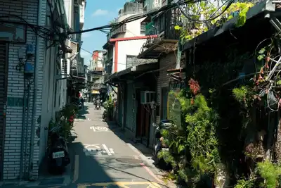 Explore a vibrant alleyway in Taipei, Taiwan, showcasing urban life and lush greenery.