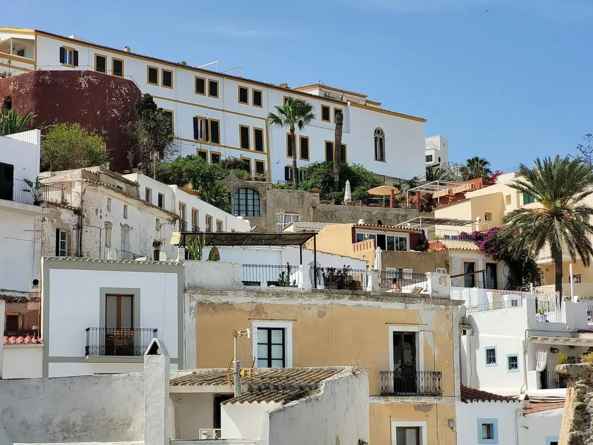Charming view of Mediterranean-style buildings and palm trees in Ibiza, Spain.