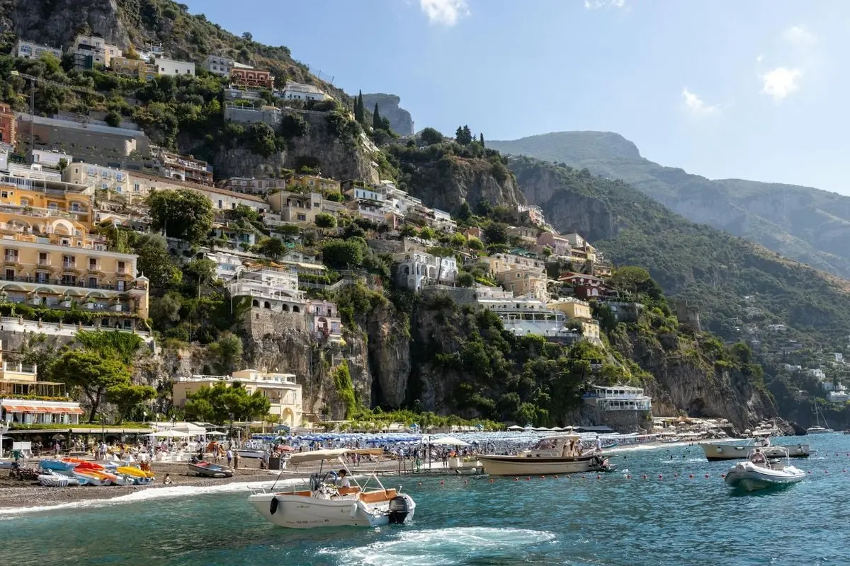 Vibrant view of Positano by the sea, nestled against lush hills, perfect for travel and leisure.