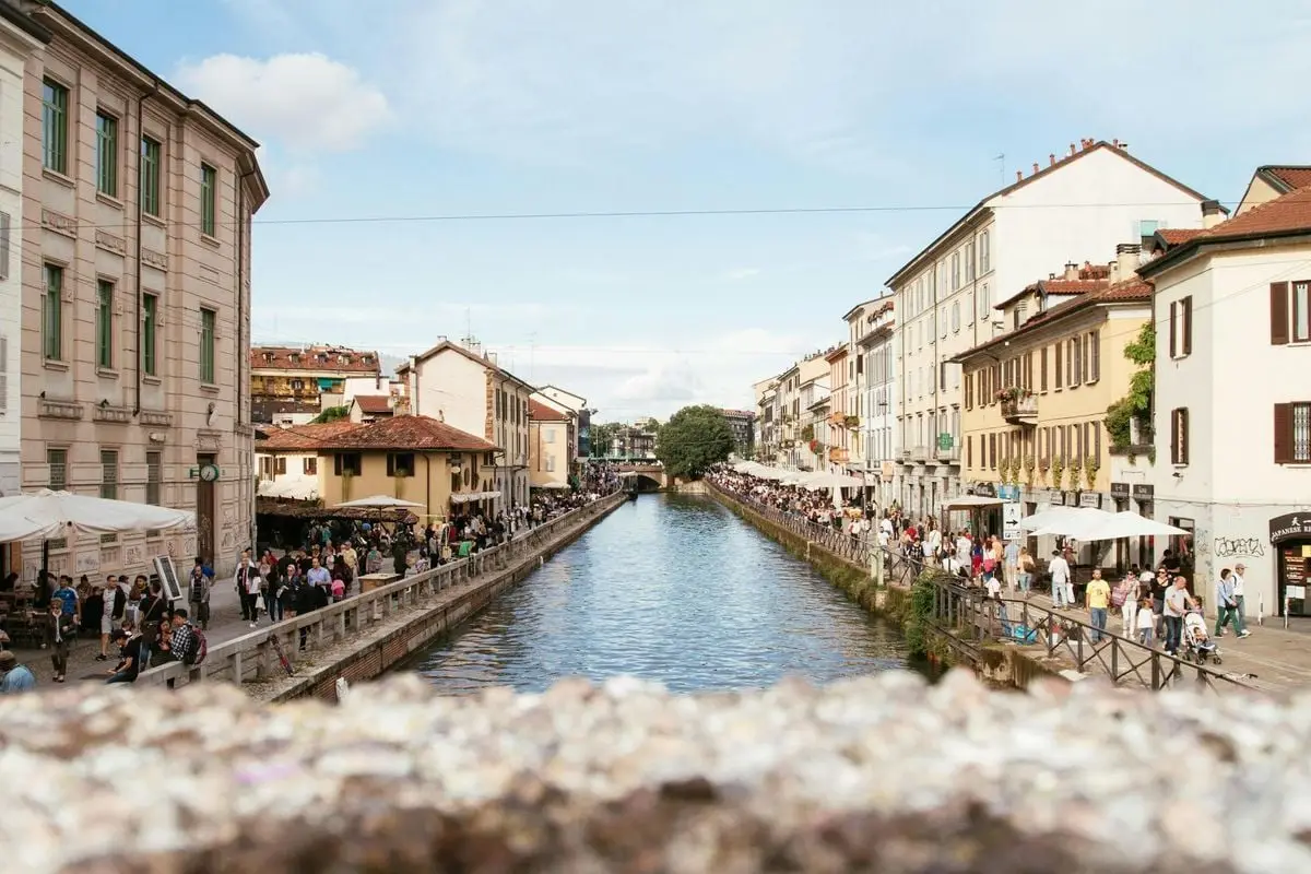 Bustling streets along the canal in Milano, showcasing vibrant city life and historic architecture.