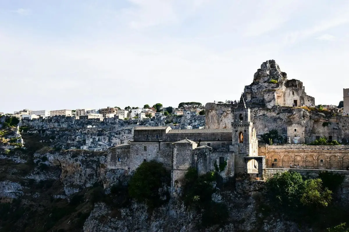 Scenic view of Matera's ancient stone buildings and cliffs in Apulia, Italy.