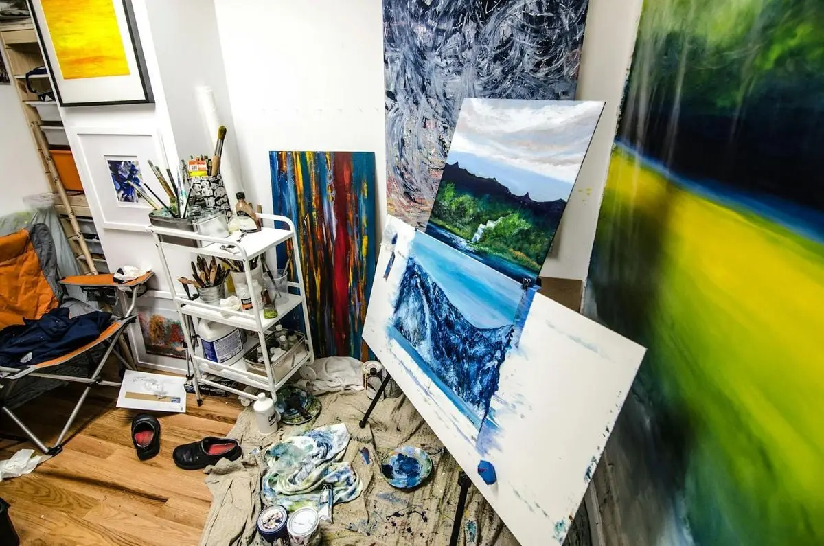 Colorful art studio showcasing vibrant paintings and creative tools inside a cozy space.