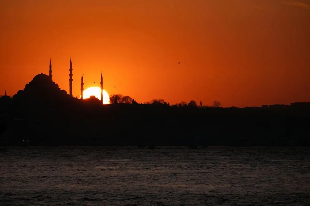 Stunning silhouette of Hagia Sophia during a vibrant sunset over Istanbul's coast.