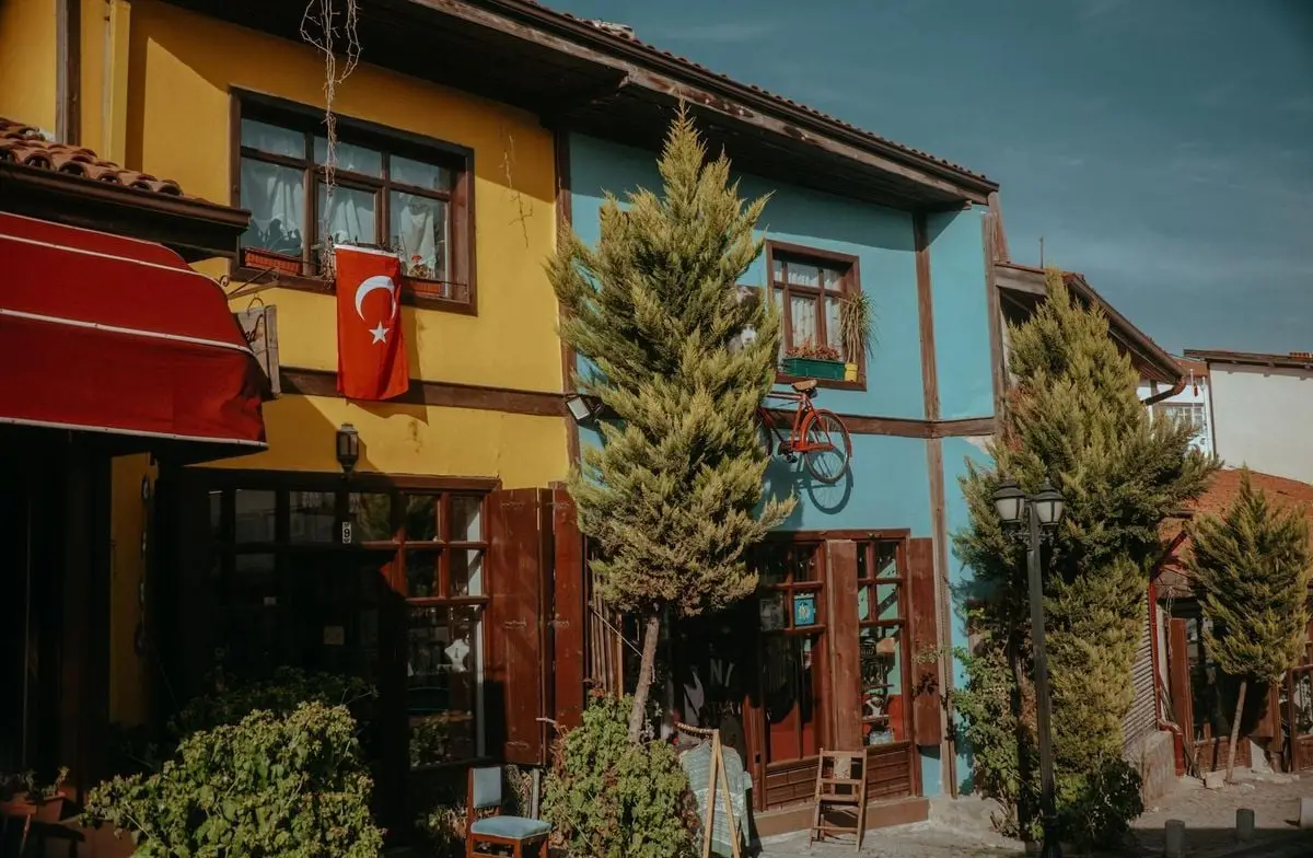 Charming street with colorful buildings and a Turkish flag, reflecting traditional architecture.
