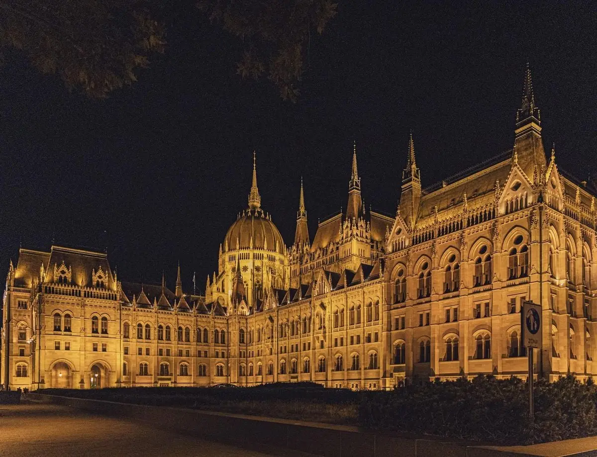 Illuminated view of the Hungarian Parliament Building in Budapest at night, showcasing gothic architecture.