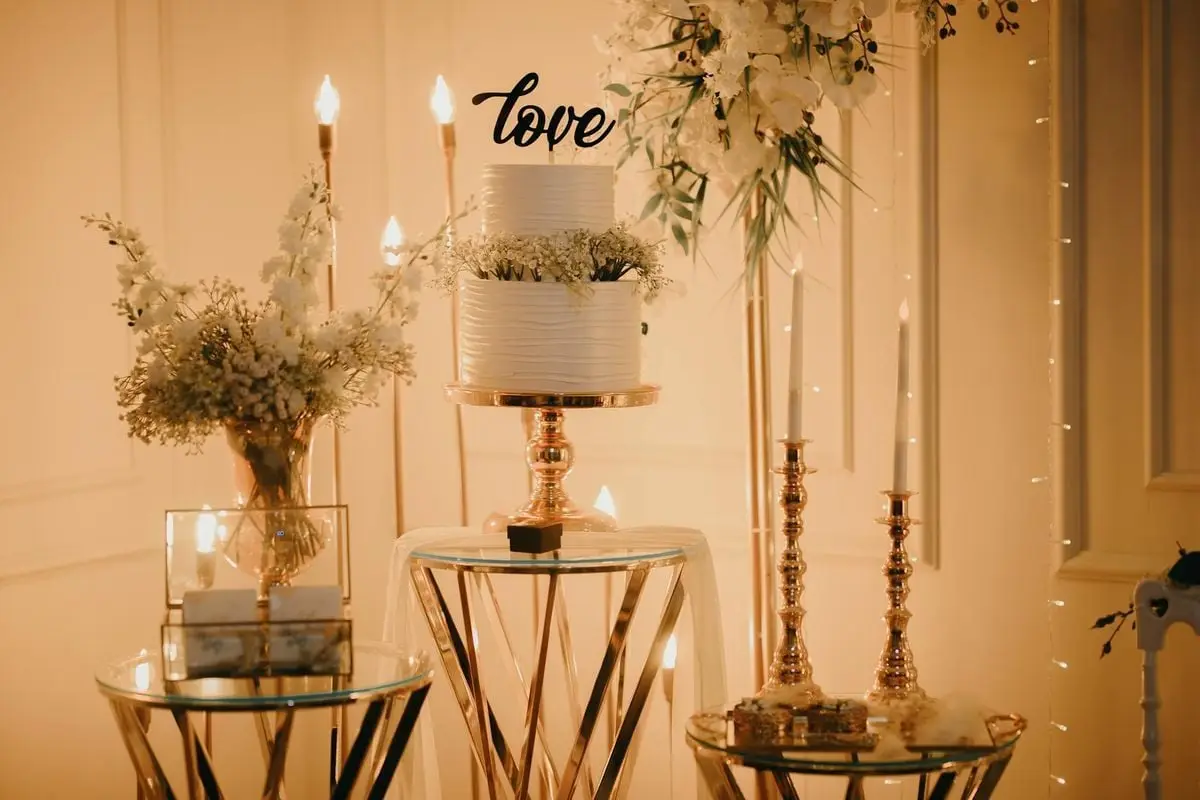 Captivating wedding scene with a two-tier cake, candles, and floral arrangements, exuding romance.