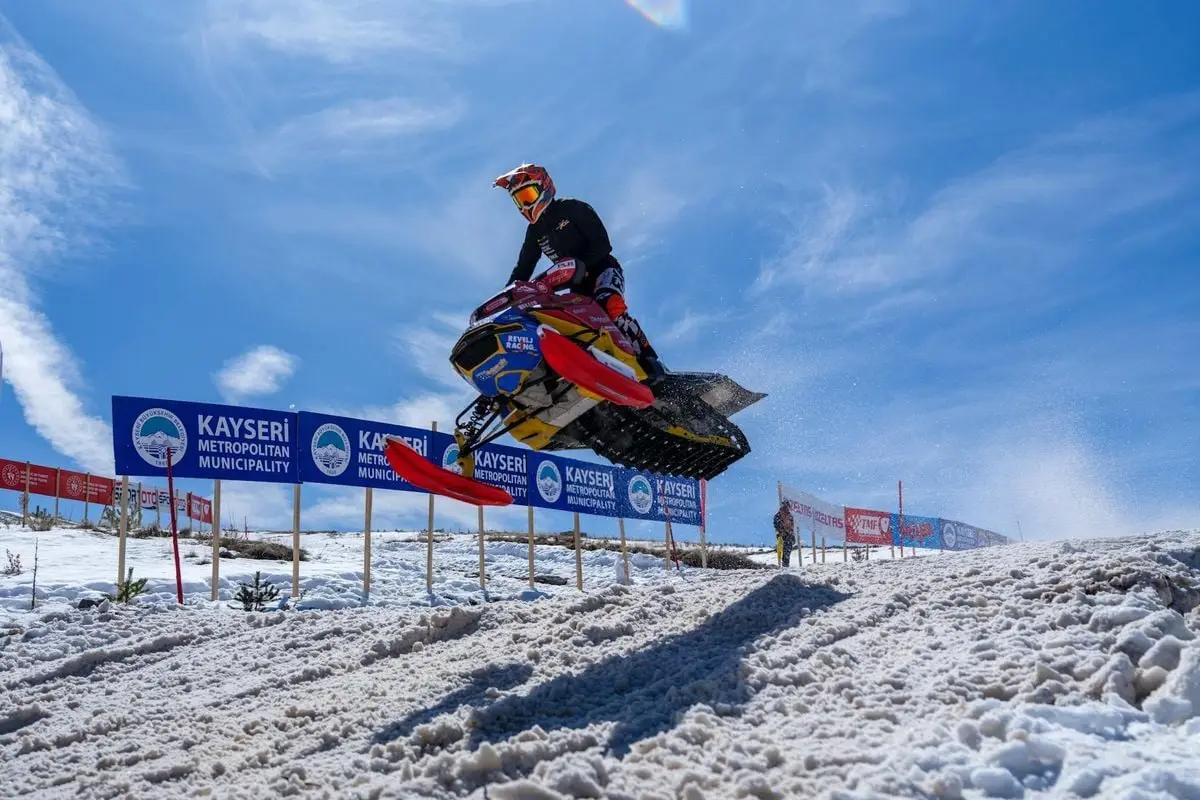Snowmobile racer performs an impressive jump at a winter sports event in Kayseri.