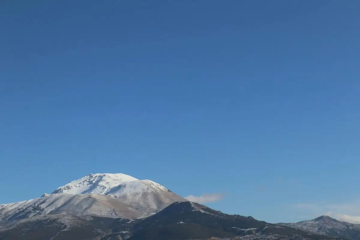 Captivating view of a snow-capped mountain under a clear blue sky in Isparta, Türkiye.