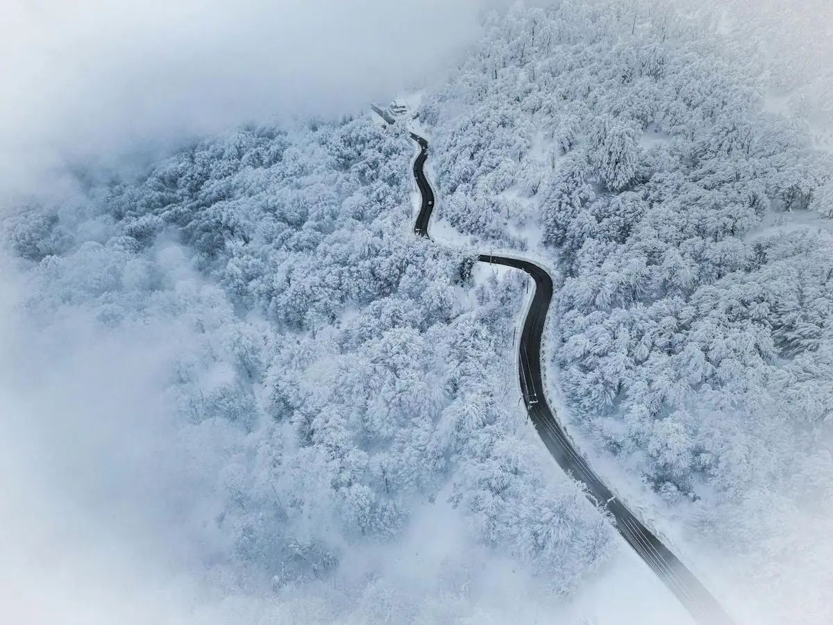 A stunning aerial view of a snow-covered forest road in Kartepe, Türkiye.