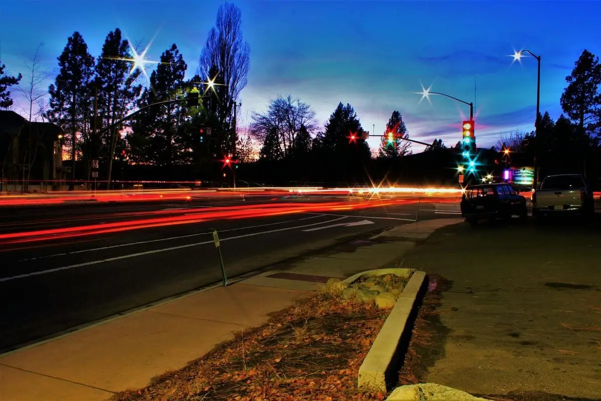 Vibrant long-exposure shot capturing light streaks of traffic under a twilight sky in urban setting.