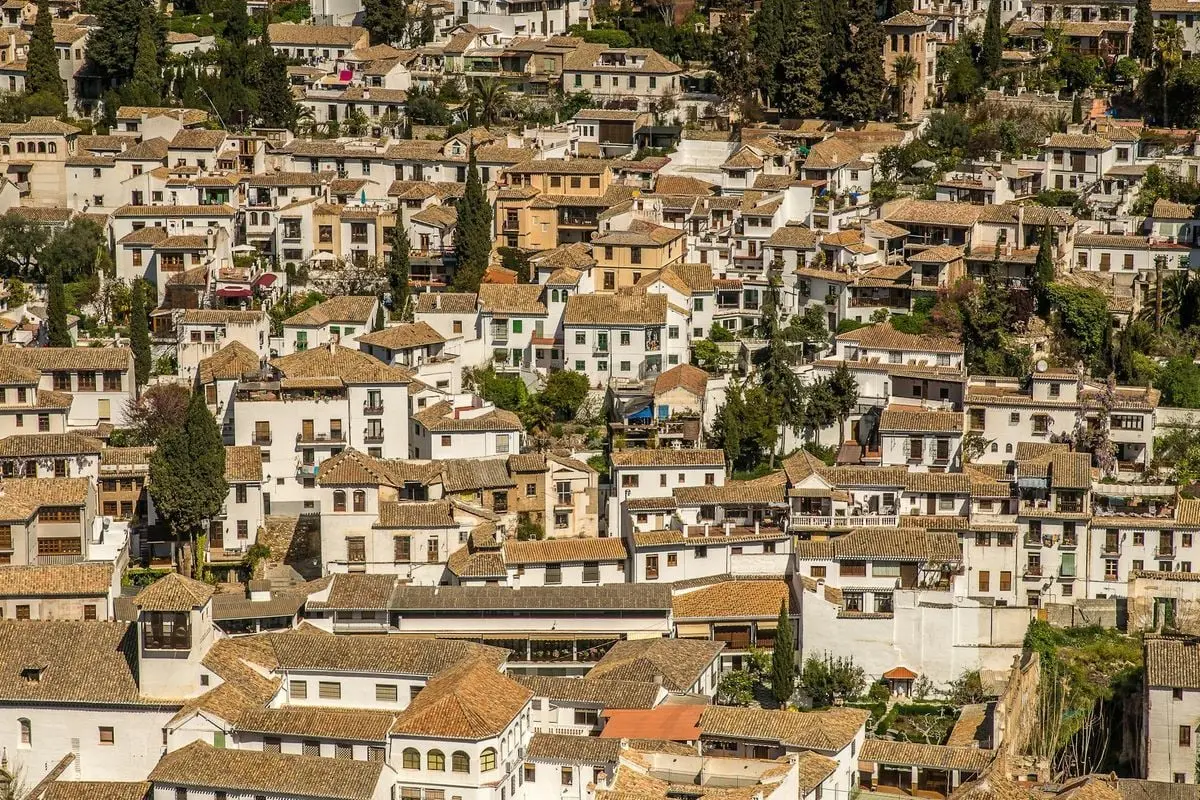 Aerial view of a dense historic neighborhood in Granada, Spain, showcasing traditional Spanish architecture.