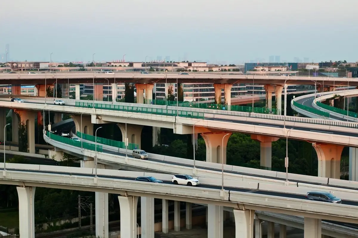 Aerial view of a modern highway interchange at dusk with flowing traffic.
