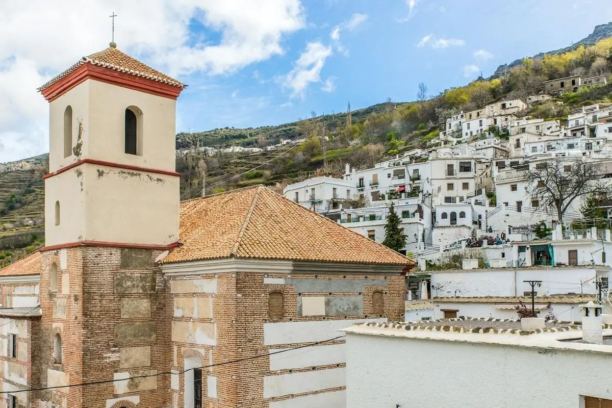 Scenic view of a Mediterranean village with a prominent church tower in Spain.