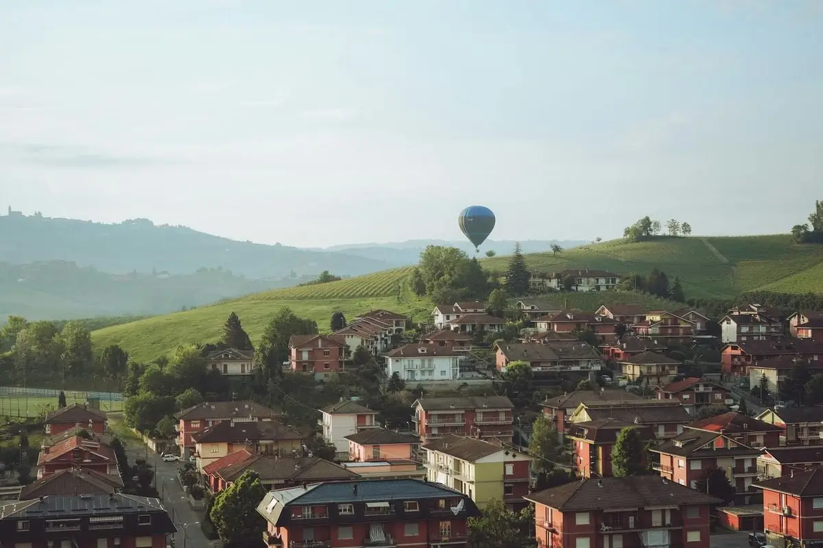 Charming landscape of Barolo, Italy with hot air balloon over rolling hills.