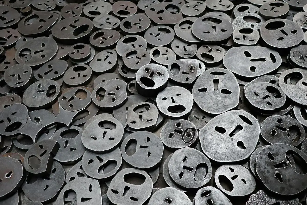 Modern art installation featuring metal face sculptures in Berlin, Germany.