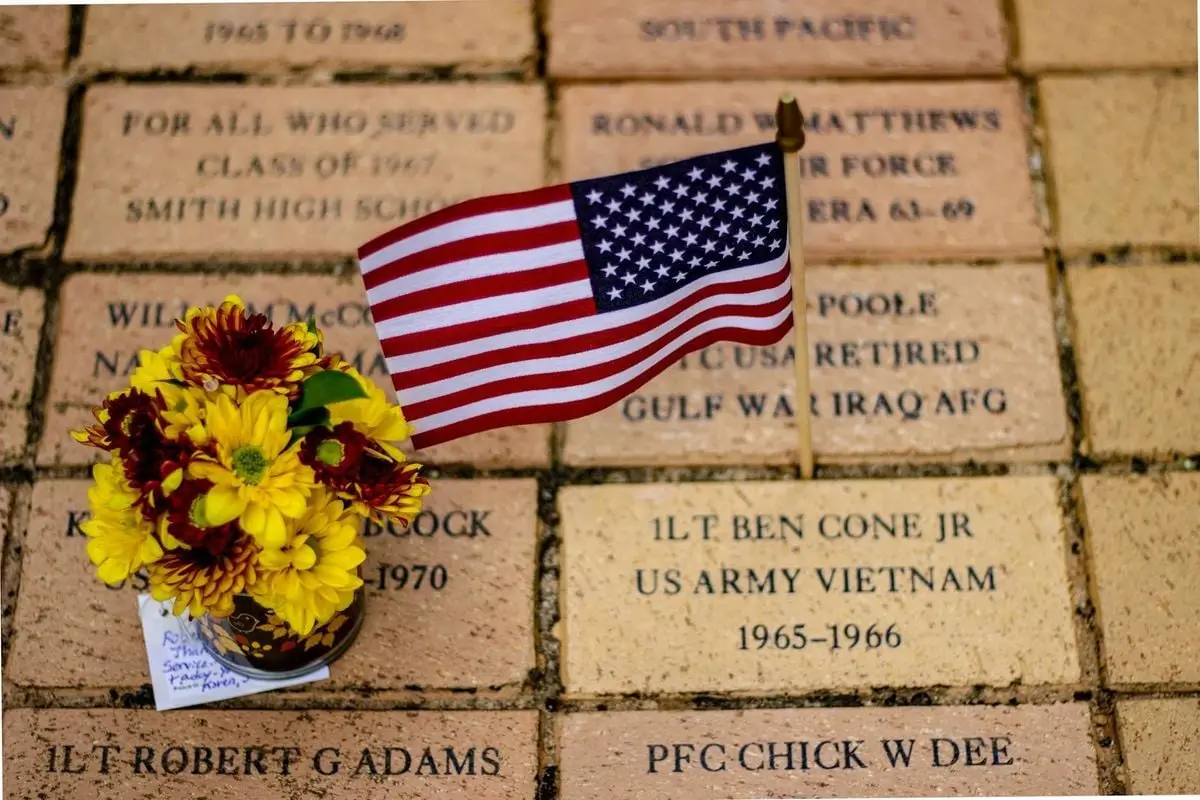American flag and flowers at a memorial in Greensboro, honoring veterans.