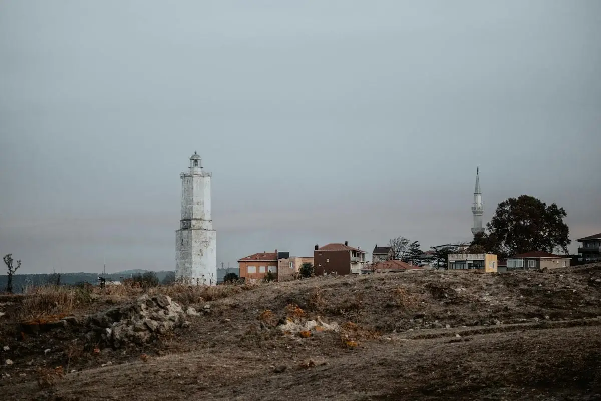 İstanbul skyline featuring a lighthouse and mosque, with a rustic foreground.