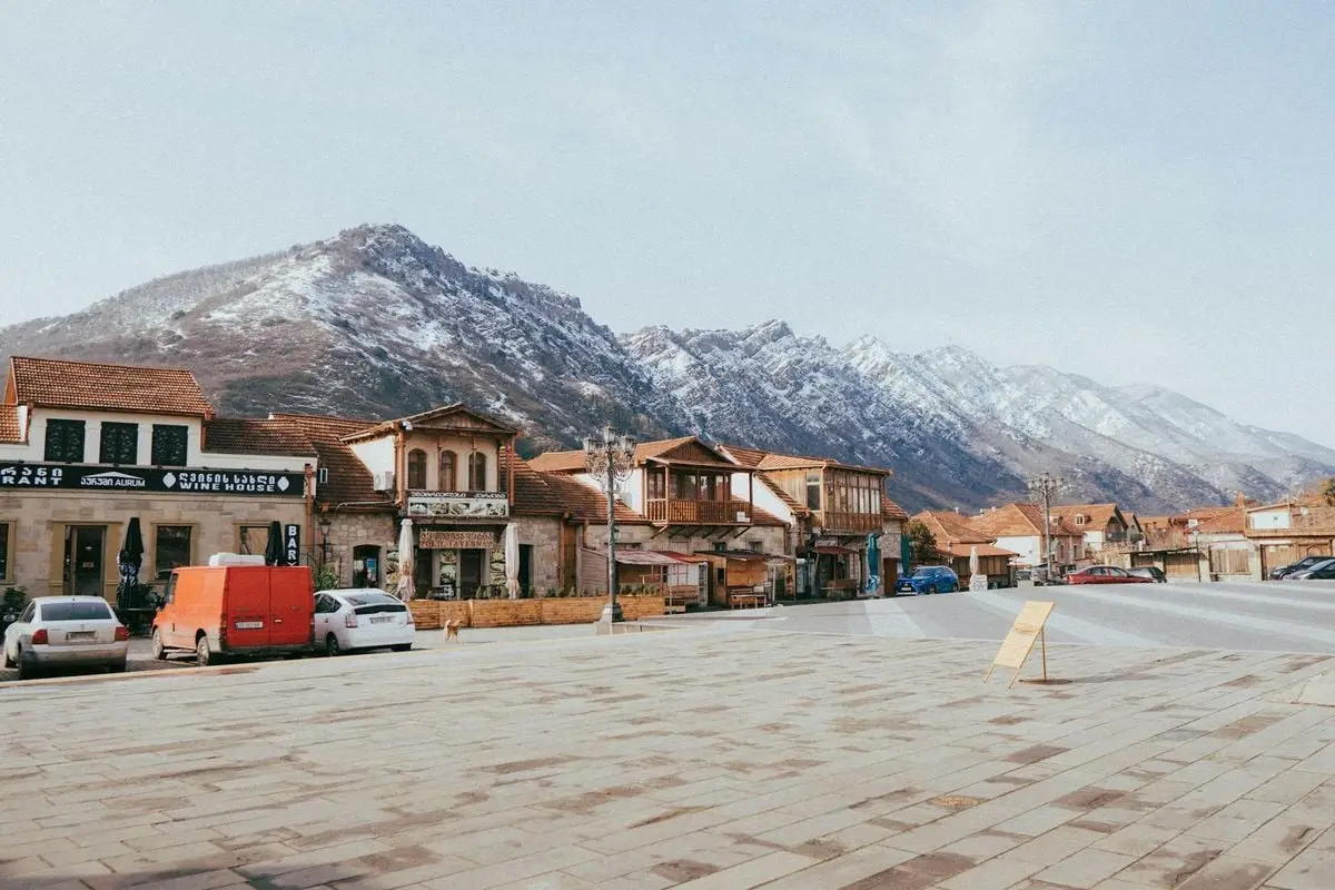 A picturesque view of Mtskheta town with stunning mountains in the background, showcasing local architecture.