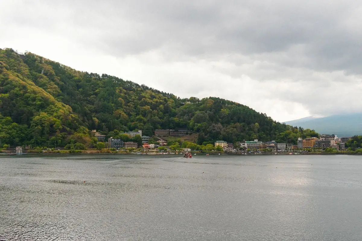 Peaceful landscape of Lake Kawaguchi with lush hills and cloudy sky, ideal for travel inspiration.