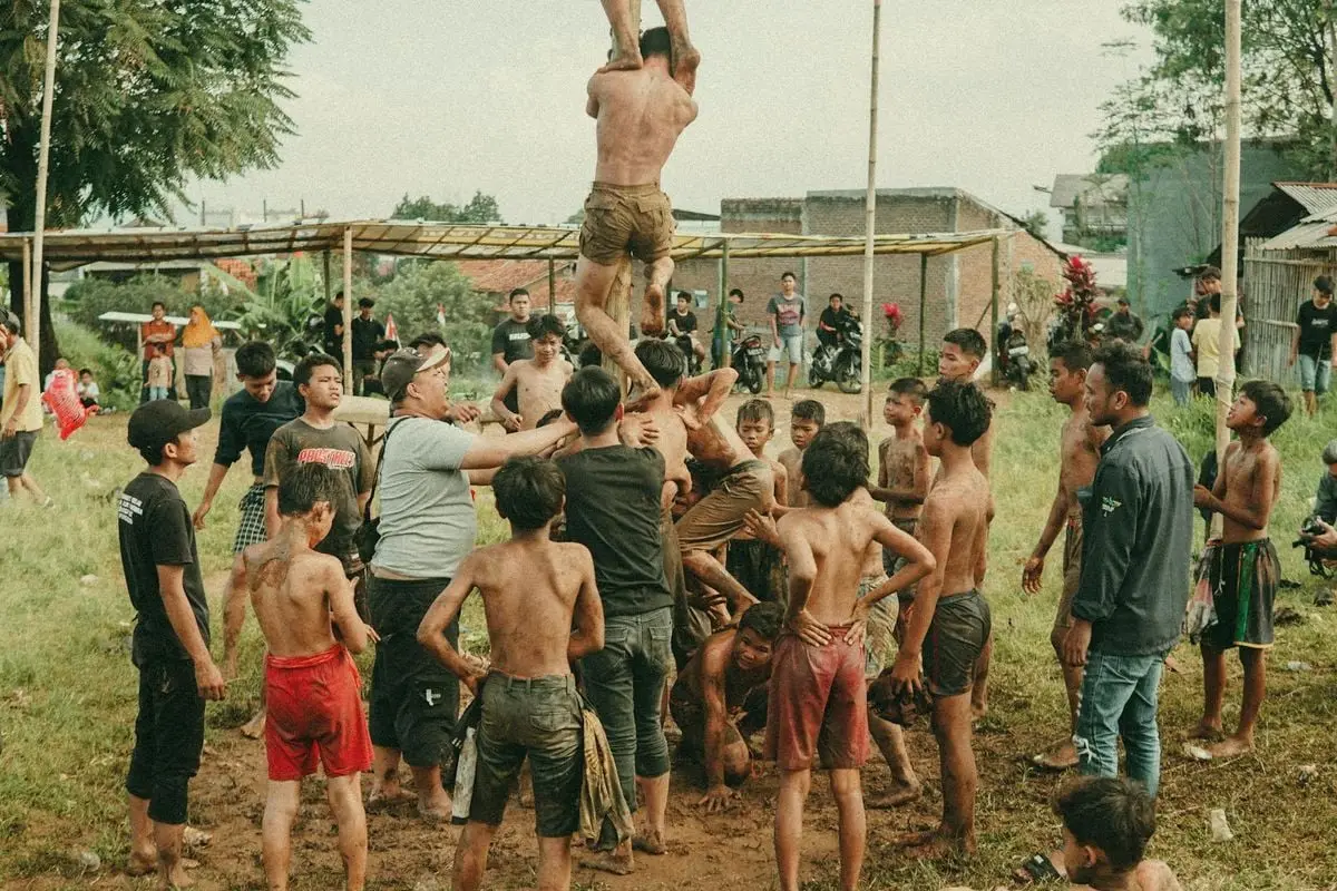 People enjoy the traditional Panjat Pinang game during an Indonesian Independence Day celebration.