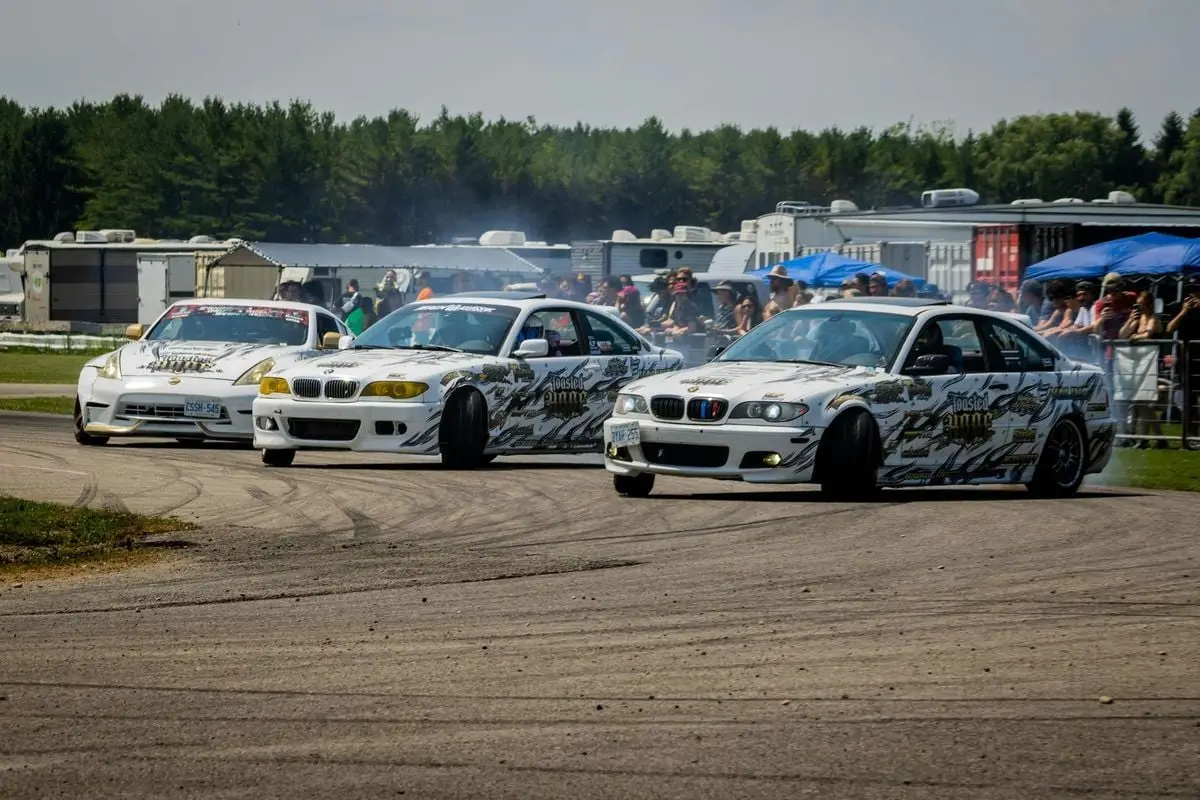 High-speed cars drifting on a racing track with spectators watching.