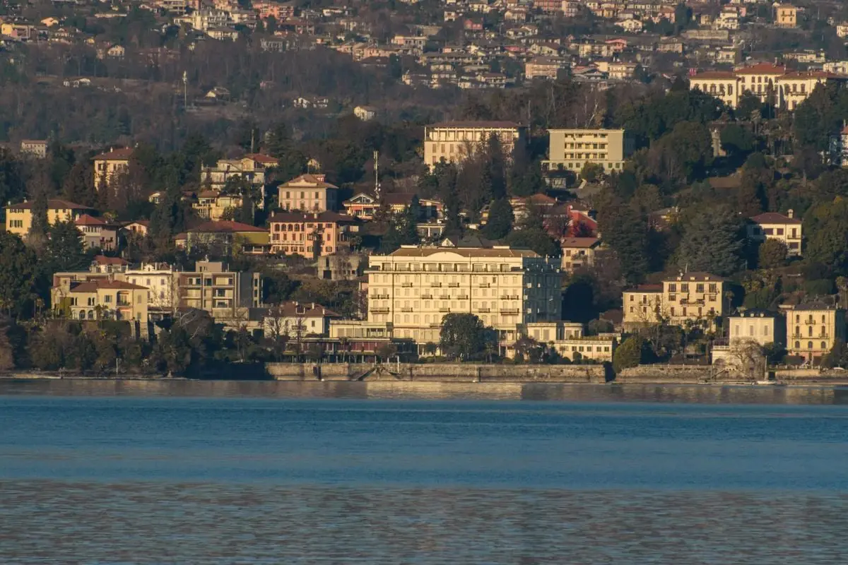 Idyllic lakefront town with hillside houses and scenic views across the water. Captured in daylight.