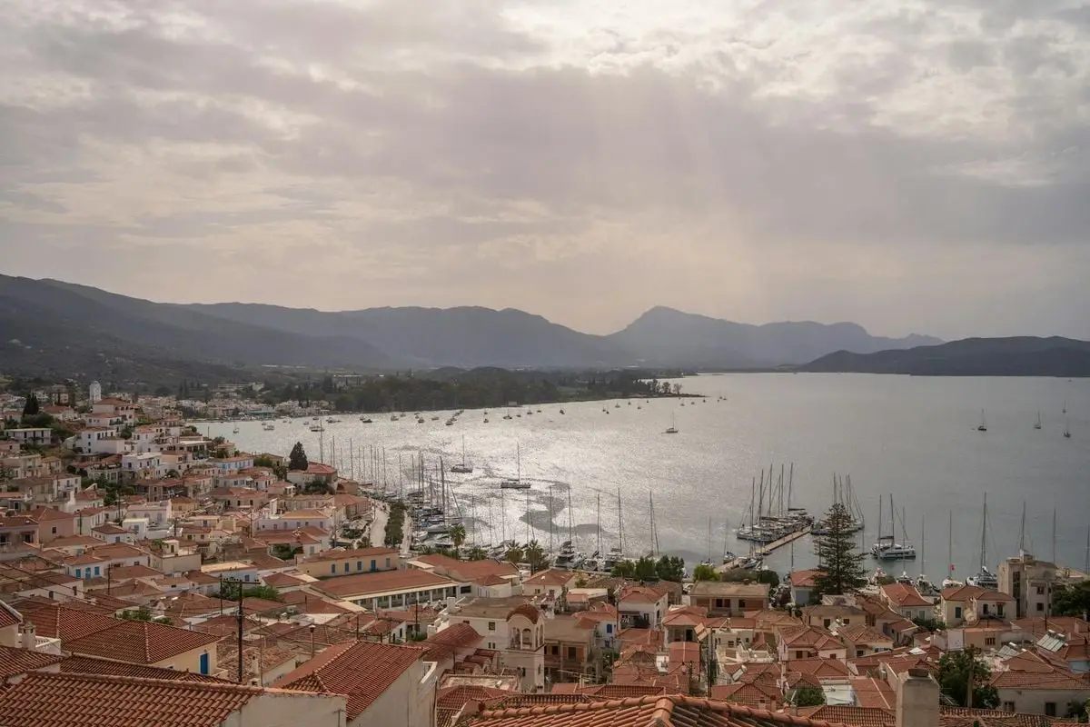 Aerial view of a quaint coastal town with boats docked along the serene seaside.