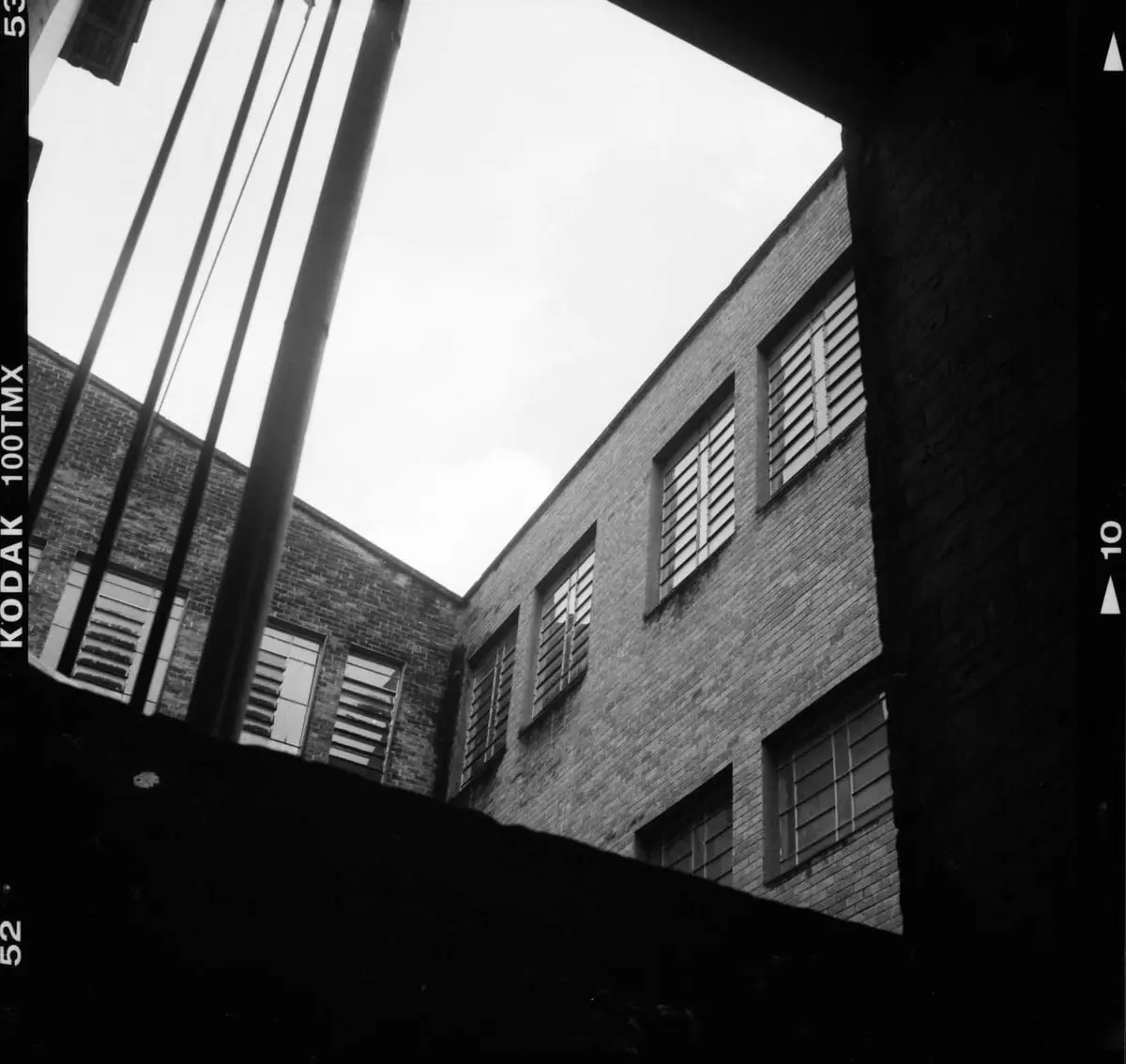 Black and white image of urban architecture with a view from below, highlighting geometric design.