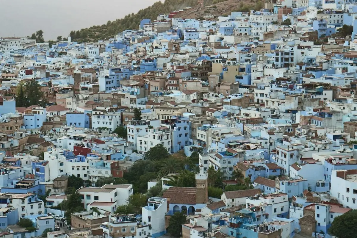 Explore the distinctive blue architecture of Chefchaouen, Morocco in this evocative aerial view.