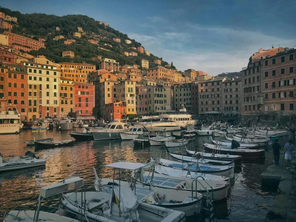 A scenic view of Camogli harbor, featuring vibrant buildings and boats in Liguria, Italy.