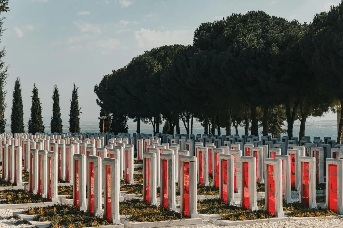 Rows of Çanakkale war cemetery monuments under clear skies, honoring sacrifice.