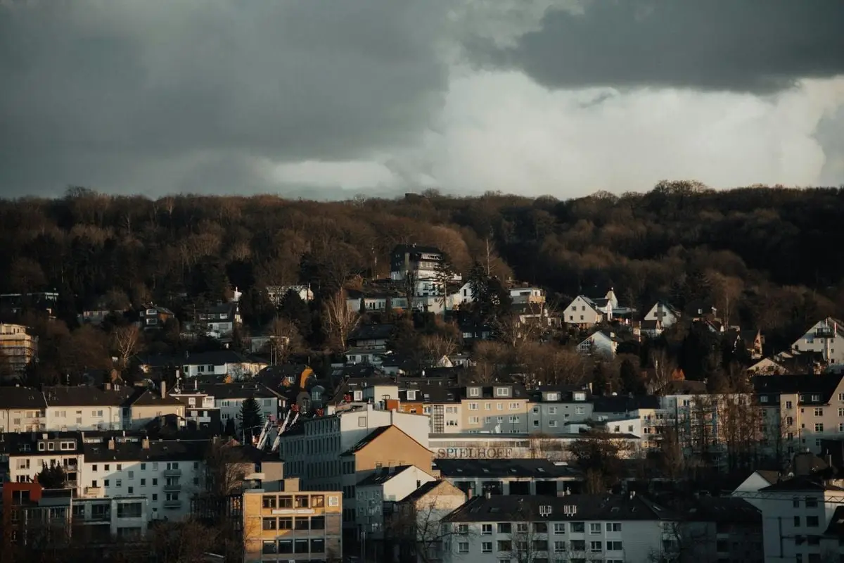Aerial view of Wuppertal, Germany featuring houses and dark clouds, offering a moody urban atmosphere.