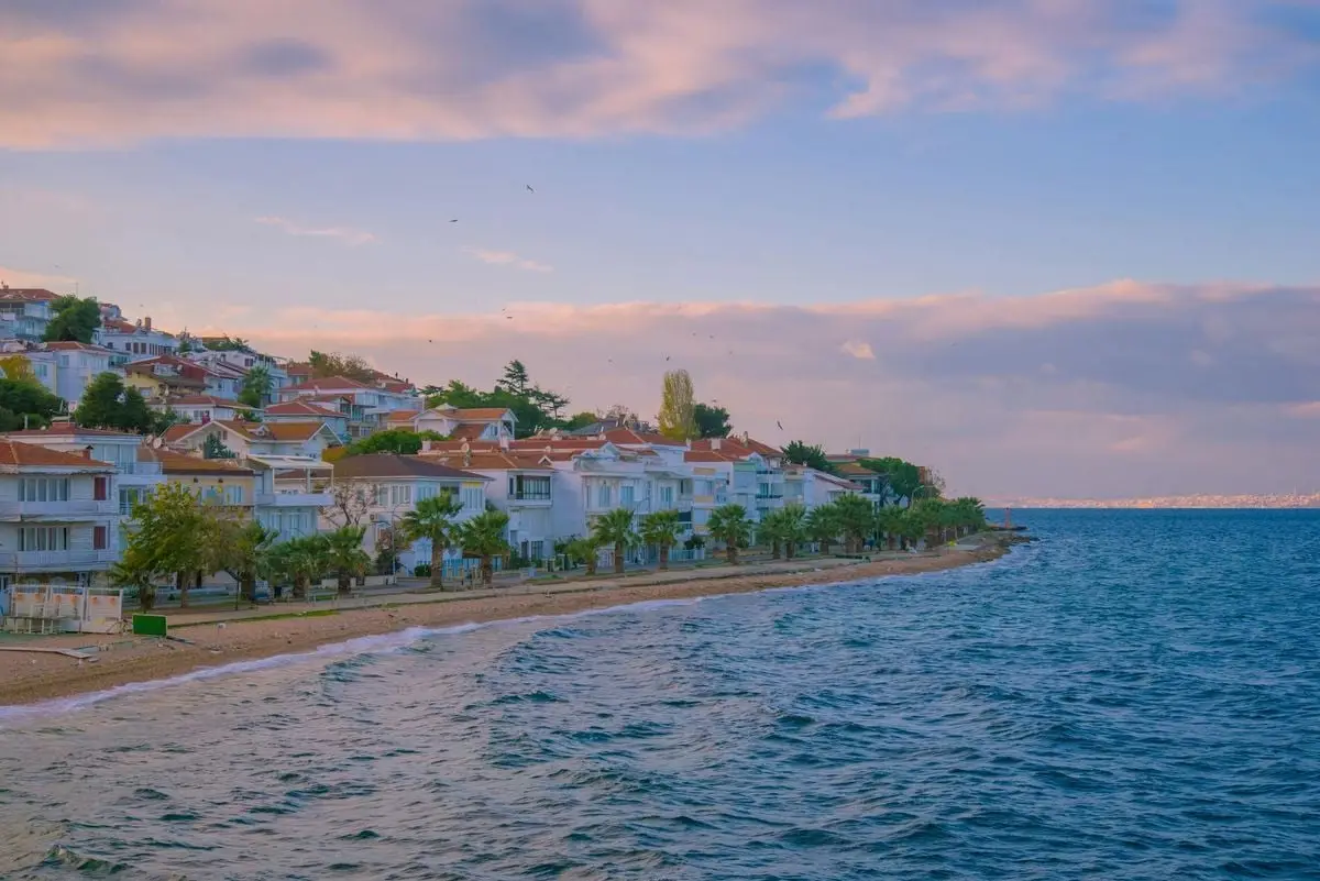 Picturesque coastal town in Turkey with houses lining the sea during a serene sunset.