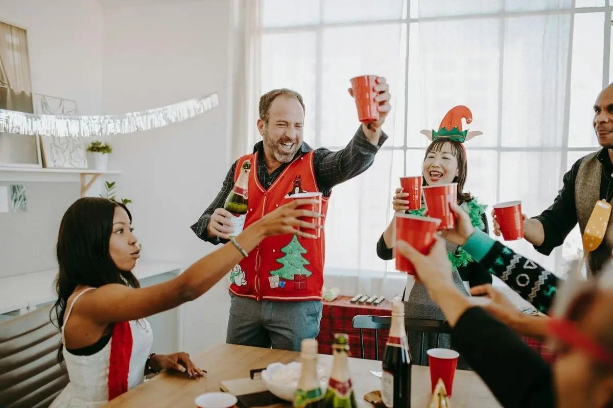 Festive office celebration featuring coworkers exchanging toasts and enjoying holiday cheer.