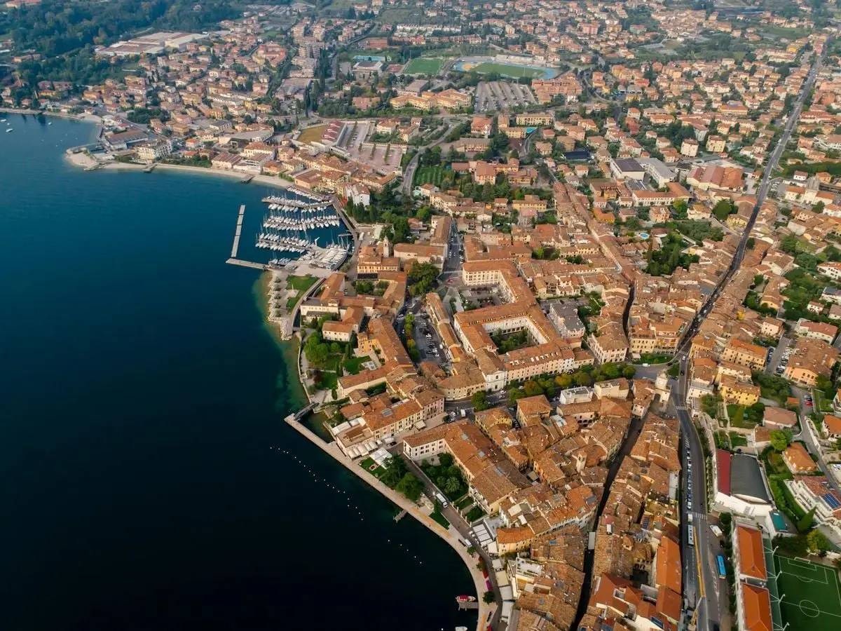Aerial photo showcasing the vibrant architecture of an Italian lakeside town beneath a clear sky.