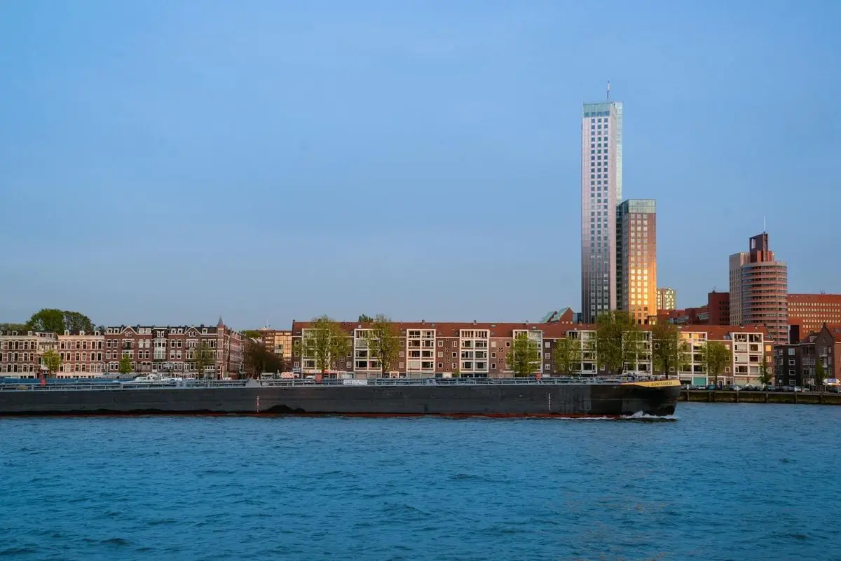 A captivating skyline of a modern city with a skyscraper reflected in calm waterfront waters.