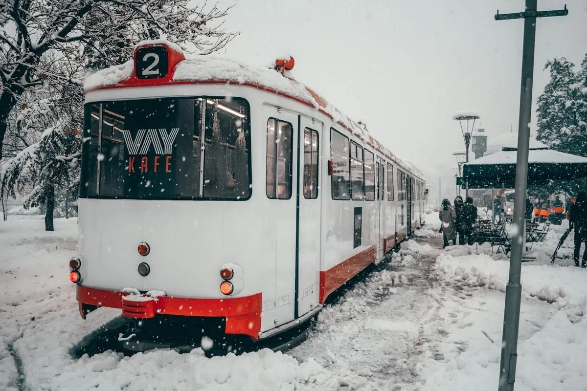 Tramway covered in snow near a café in Konya, Türkiye during a winter snowstorm.