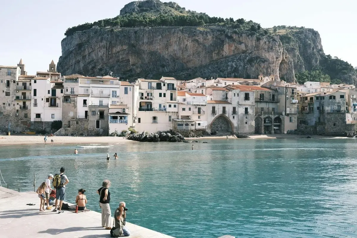 Charming coastal view of Cefalù, Sicily with historic buildings and clear waters.