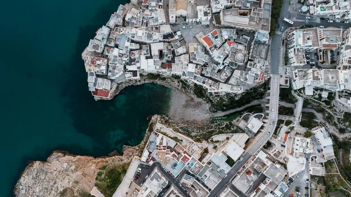 Drone shot capturing the unique architecture and coastline of Polignano a Mare, Italy.