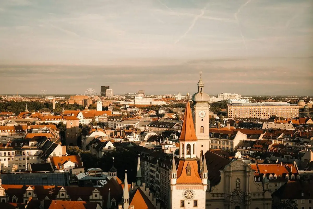 Aerial view of Munich showcasing historical buildings and vibrant urban landscape at sunset.