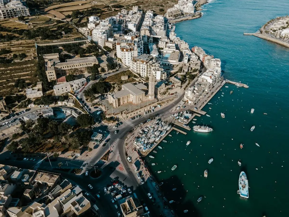 Stunning aerial view of Wied il-Għajn's marina and coastal buildings in Malta, capturing vibrant waterfront life.