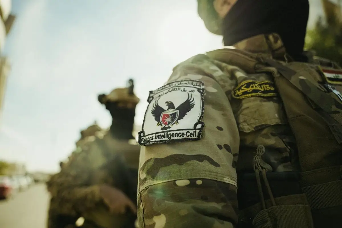 Detailed view of a military uniform with a badge in bright daylight.