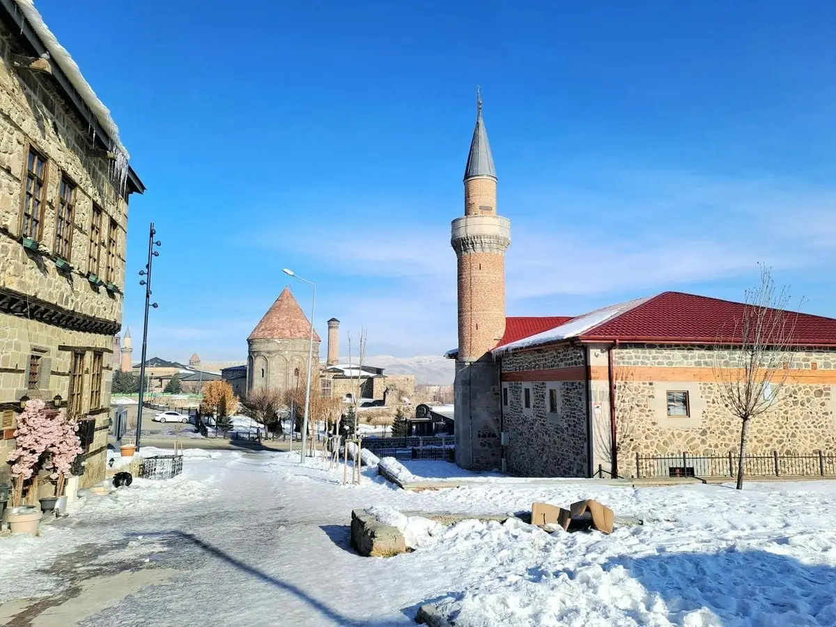 Scenic winter view of Erzurum's historic architecture and mosque in Türkiye.