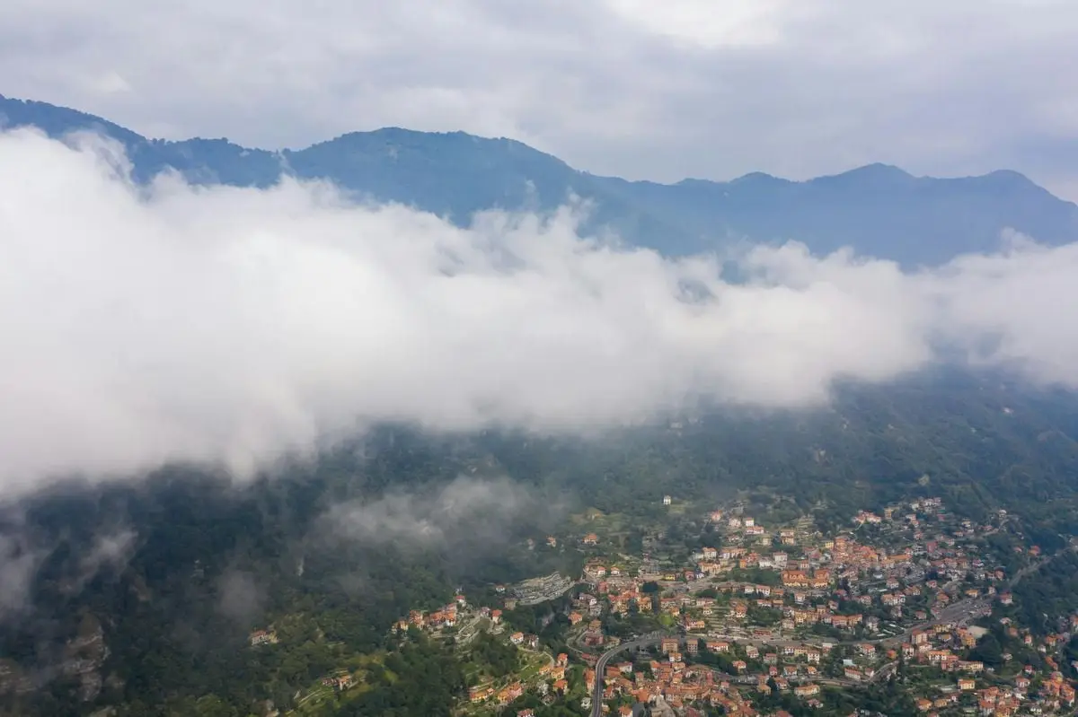 A stunning aerial view of a picturesque town nestled among mountains and clouds.
