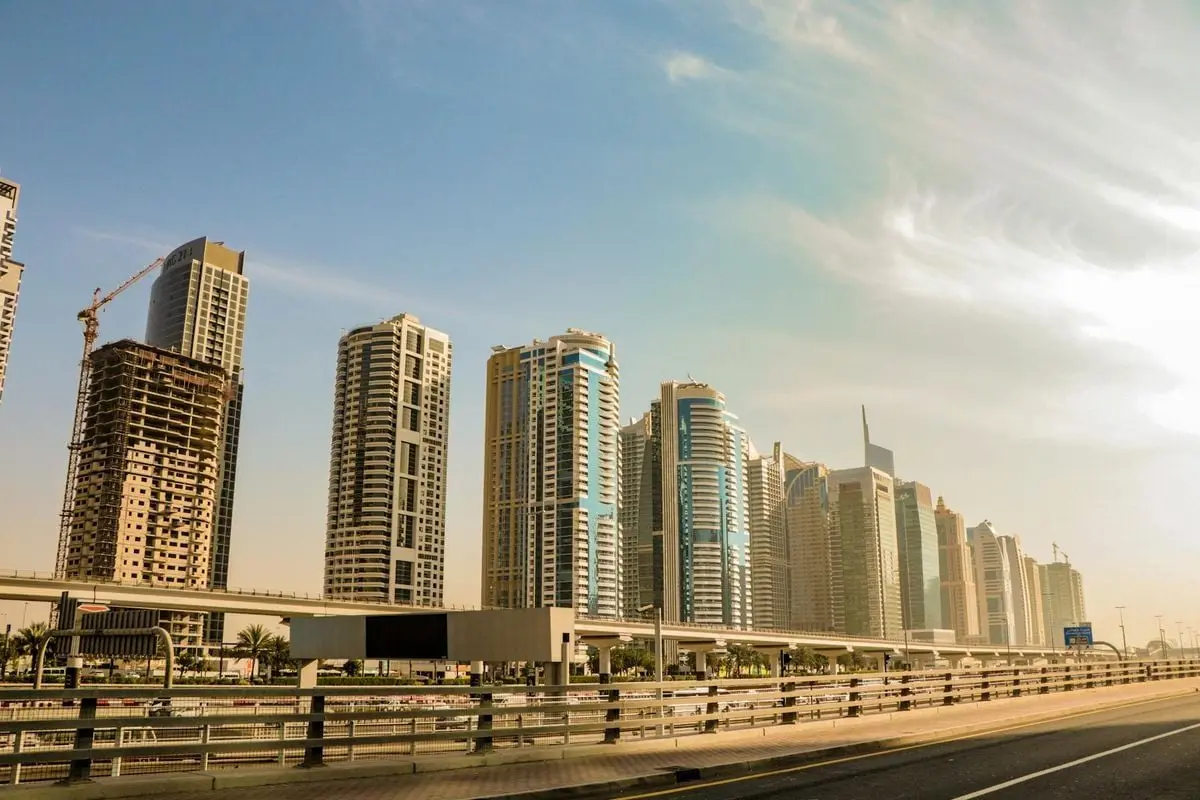 Highrise buildings in Dubai shine under a clear sky, showcasing urban architecture.