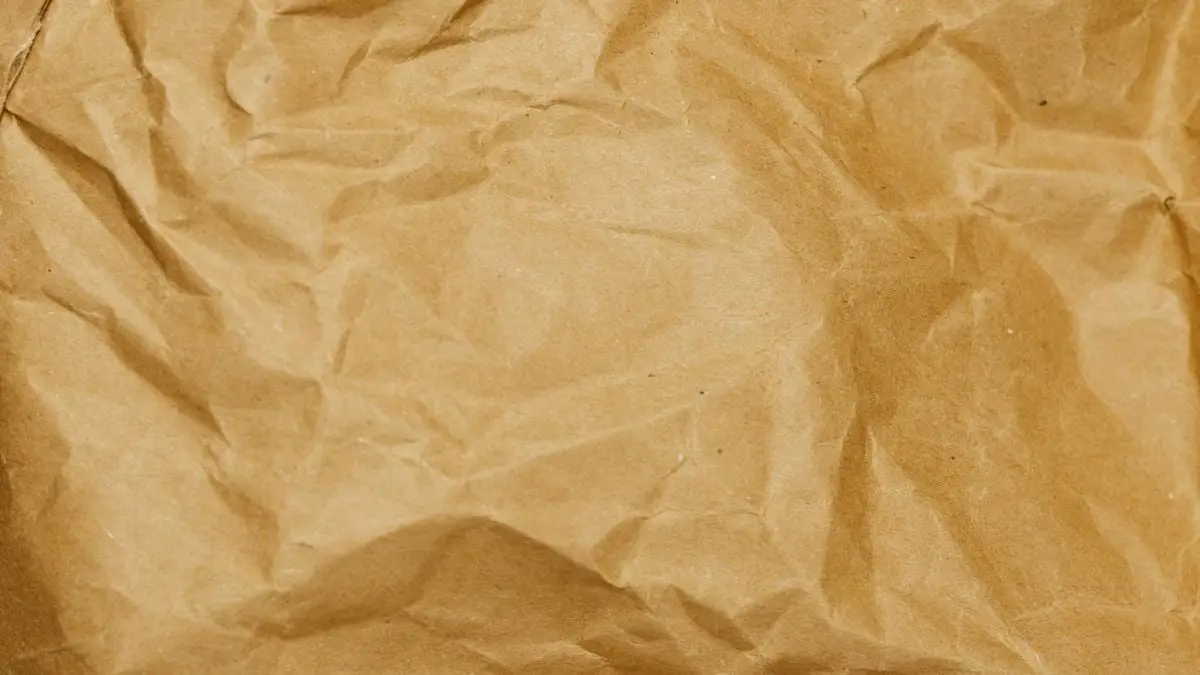 Detailed close-up of a crumpled brown paper texture showcasing folds and creases.