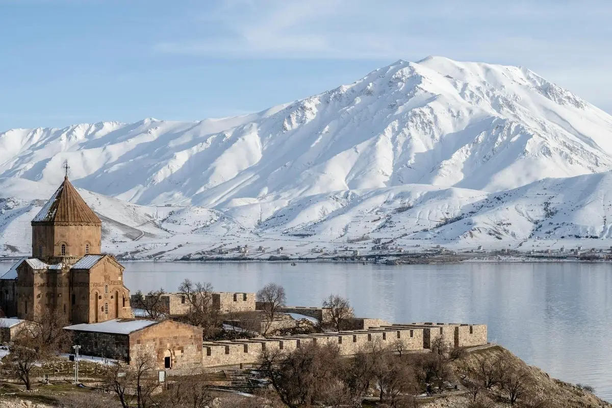 A breathtaking winter scene of Akdamar Island in Van Lake with snow-capped mountains.