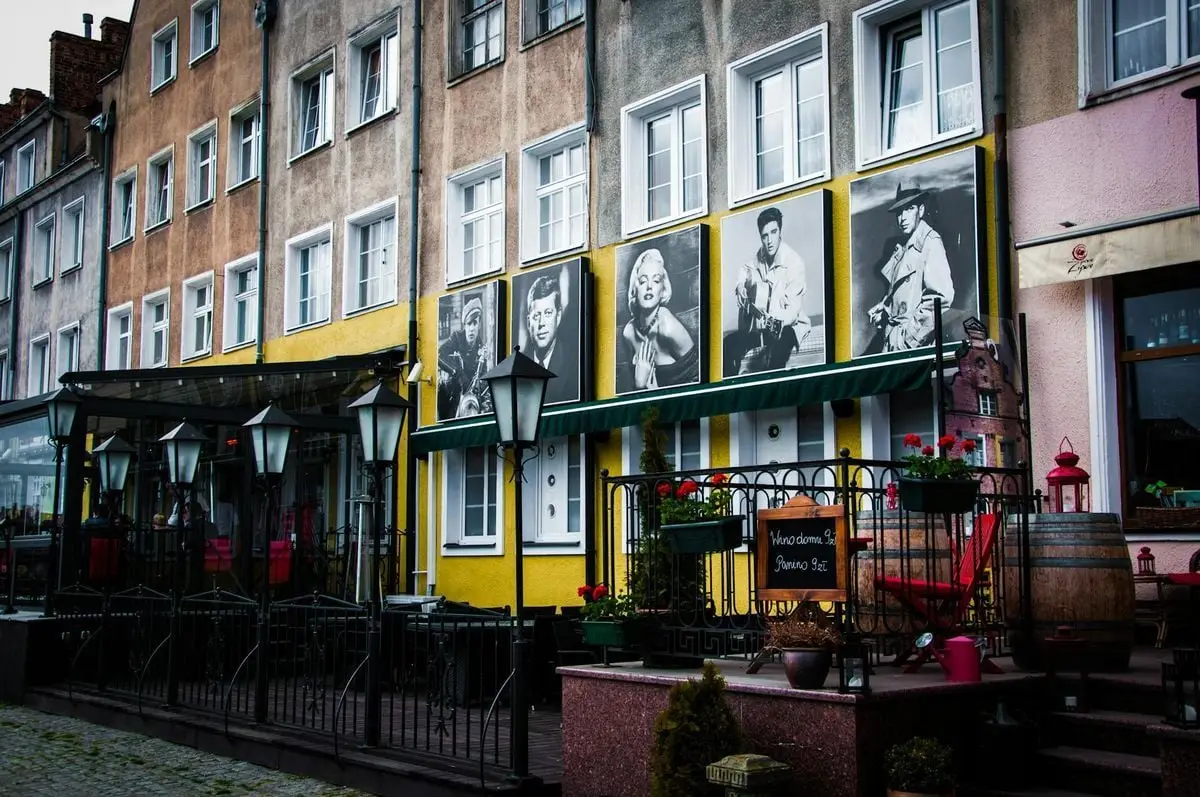 Colorful street view with classic film posters and outdoor seating in quaint European town.