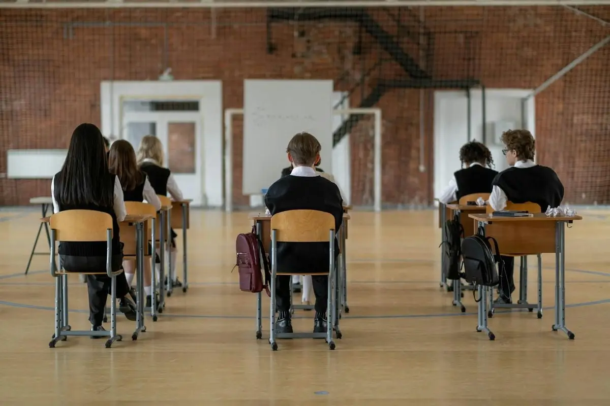 Back view of students seated in a classroom environment, focusing on studies.