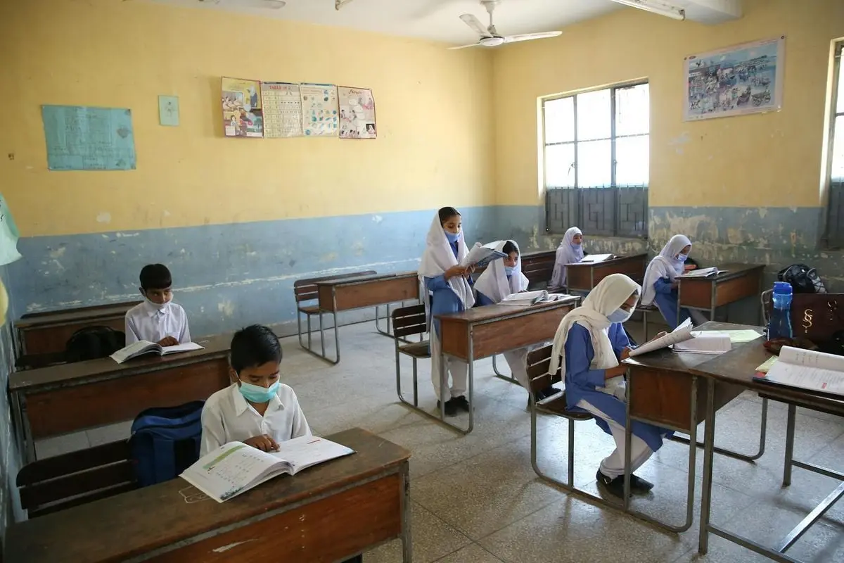 Students wearing face masks in a classroom adjusting to new learning norms.
